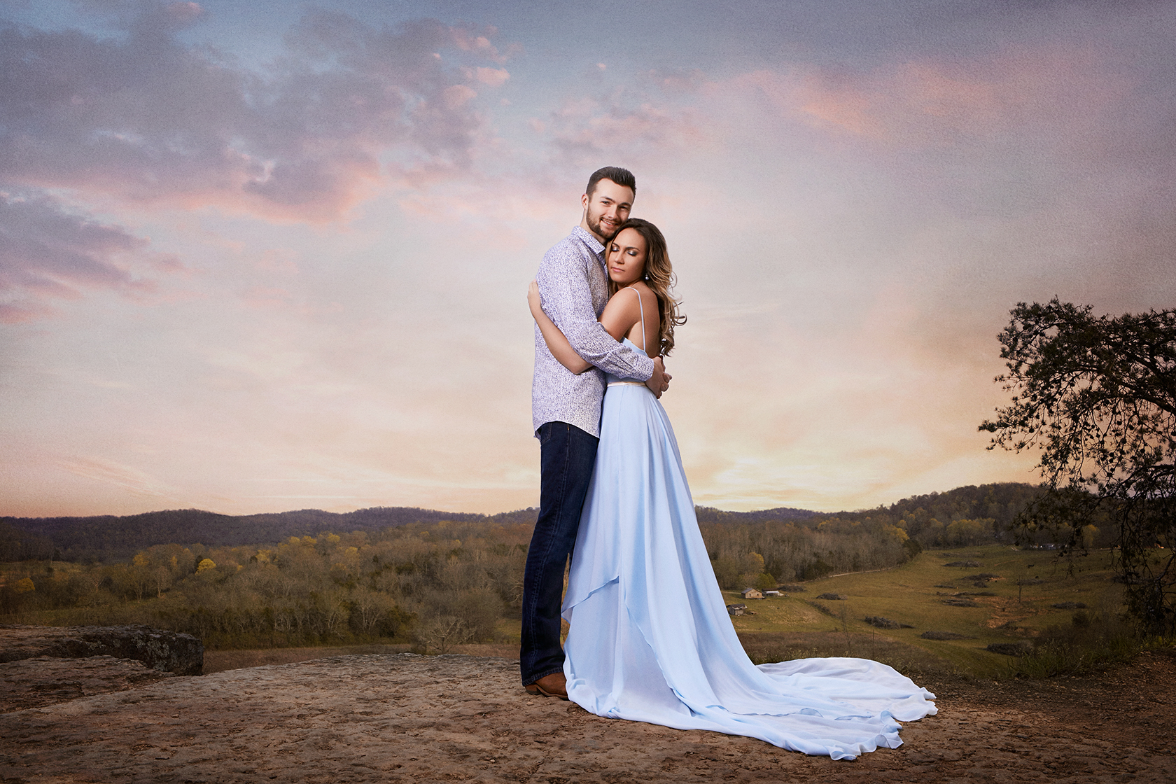 A couple embracing with a city skyline at sunset.